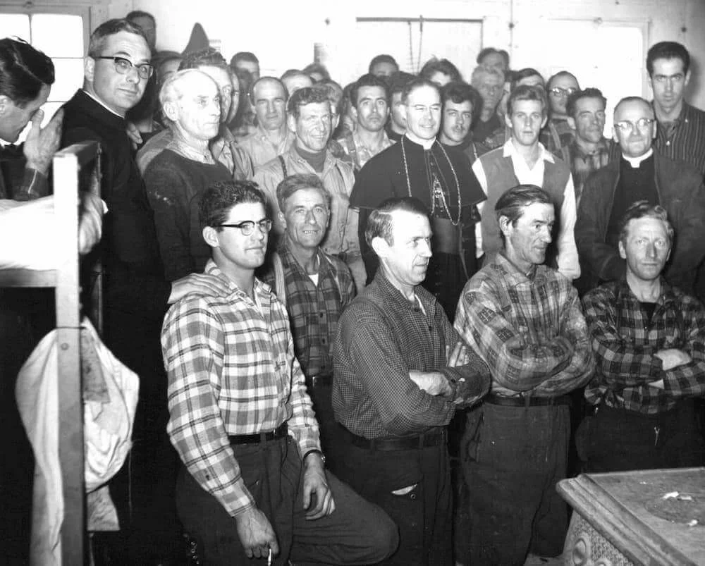 Mgr Couturier, le père Beauchemin et les travailleurs réunis pour une photographie